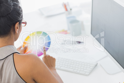 Designer working at her desk holding colour wheel