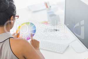 Designer working at her desk holding colour wheel