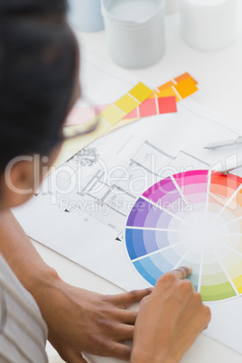 Interior designer looking at colour wheel at her desk