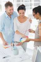 Interior designer showing colour wheel to smiling clients