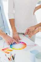Interior designer showing colour wheel to two customers