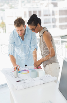 Interior designers looking at colour wheel and blueprints
