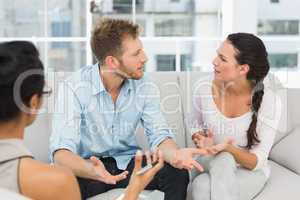 Unhappy couple arguing at therapy session