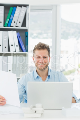 Handsome man working at his desk smiling at camera