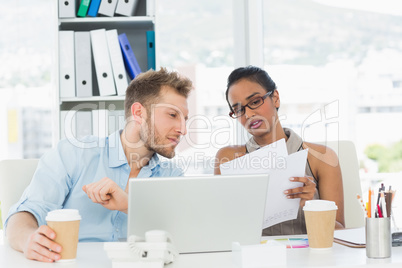 Partners working together on laptop at desk