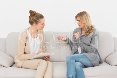 Blonde woman talking to her therapist on the couch