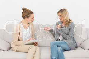 Blonde woman talking to her therapist on the couch
