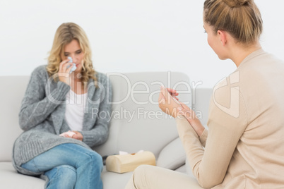 Therapist listening to crying patient on the sofa