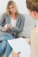 Therapist holding clipboard and listening to patient
