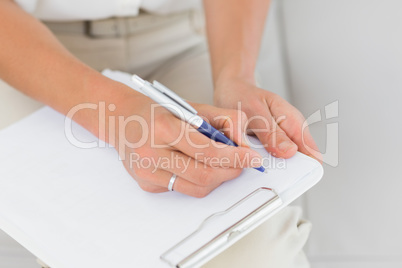 Therapist taking notes on clipboard