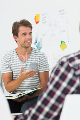 Young man talking to colleagues at a meeting Young man talking to colleagues at a meeting