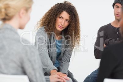 Woman comforting another in rehab group at therapy