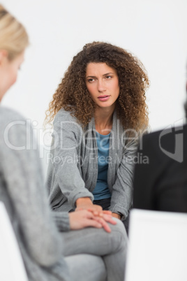 Concerned woman comforting another in rehab group at therapy