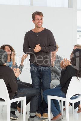 Rehab group applauding happy man standing up