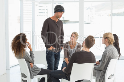 Rehab group listening to man standing up introducing himself