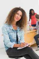 Thinking designer sitting in front of her colleagues using digit