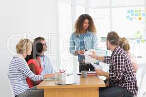 Woman presenting ideas to young designers having a meeting