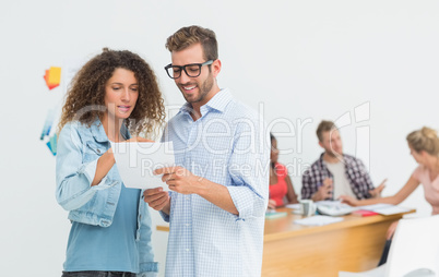 Attractive designers looking at digital tablet together