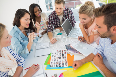 Young design team going over contact sheets at a meeting