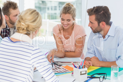 Smiling design team going over contact sheets at a meeting