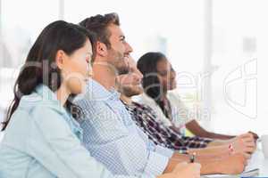 Smiling team of designers listening at meeting