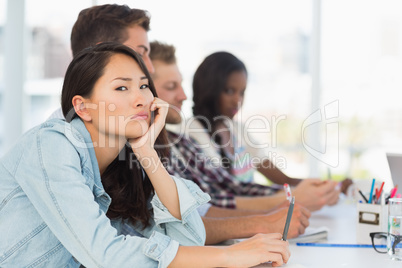 Bored woman looking at camera during a meeting