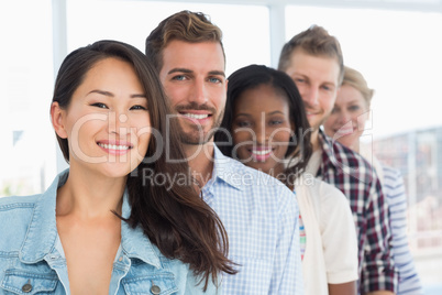 Design team standing in a row smiling at camera