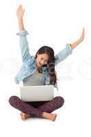 Asian woman cheering with laptop sitting on floor