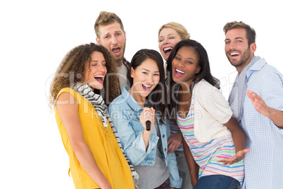 Happy group of young friends having fun doing karaoke