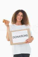 Happy volunteer holding a box of donations and jam jar