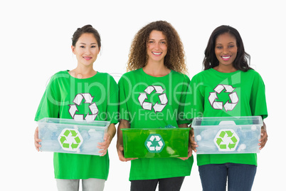 Team of environmental activists holding boxes smiling at camera