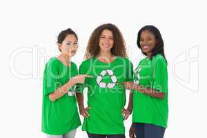 Team of environmental activists smiling at camera pointing to ts