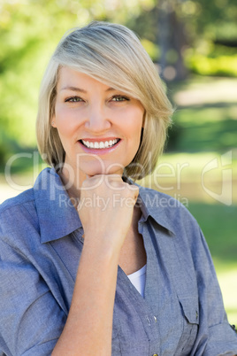 Woman with hand on chin in park