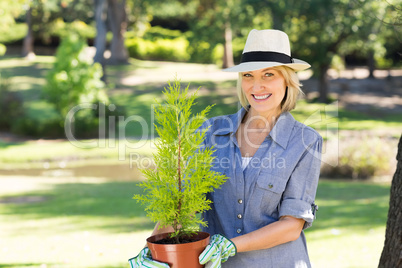 Woman holding potted plant in garden