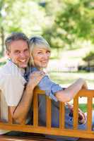 Smiling couple sitting on park bench