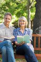 Couple with books on park bench