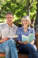 Couple holding books in park
