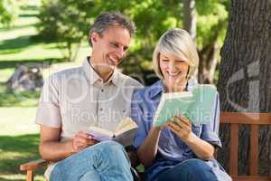 Couple reading books on bench