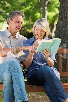 Couple reading books on bench