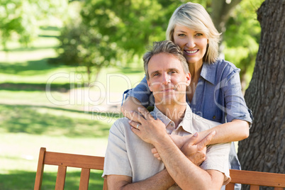 Woman embracing man from behind in park