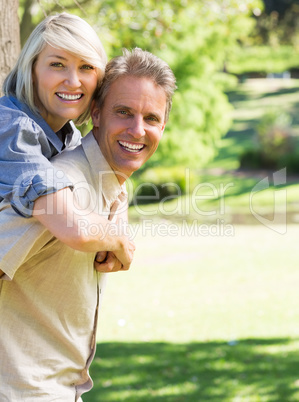 Couple enjoying piggyback ride in park