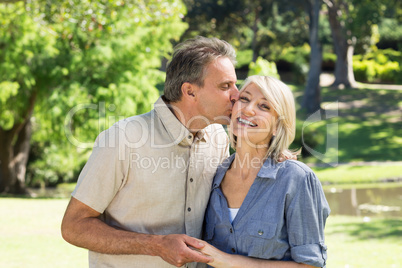 Man kissing woman in park