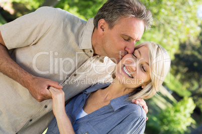 Romantic man kissing woman in park