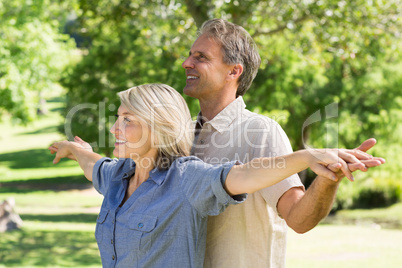 Couple arms outstretched in park