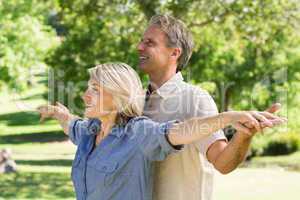 Couple arms outstretched in park