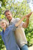 Couple with arms outstretched in park