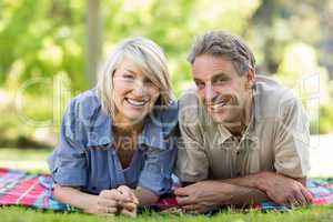 Couple lying on blanket in park