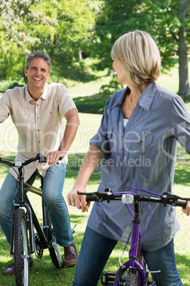 Loving couple riding bicycles in park