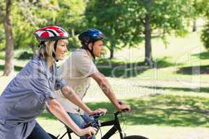 Happy couple cycling in park