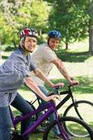 Happy couple cycling in park